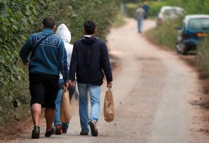 Farm workers walking through country lanes with their shopping