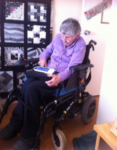 Pat with her talking machine. The quilt in the background was made by the friend she visited