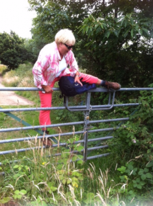 Irene climbing over locked gate