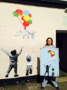 James, beside the mural, holding the original of Pigs Might Fly