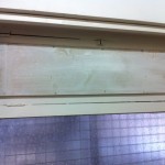 The broken window covered with wood now instead of cardboard