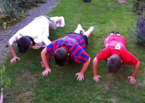 Oscar doing push ups with his brothers in the garden